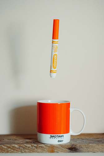 coffee cup orange Crayola crayon pen above mug pantone